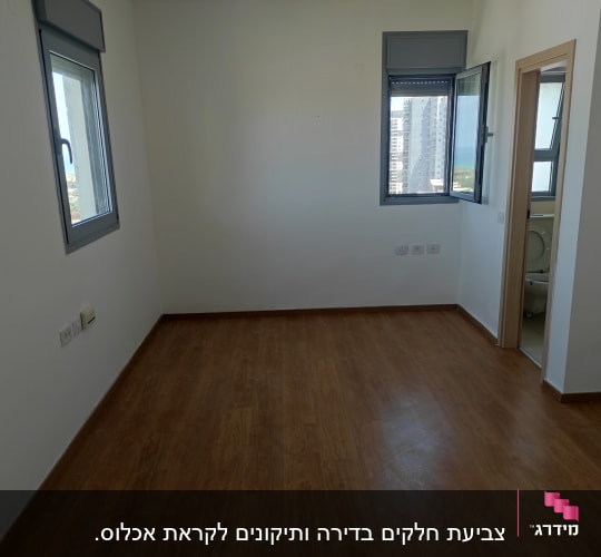 חדר ריק עם רצפת עץ וקירות לבנים